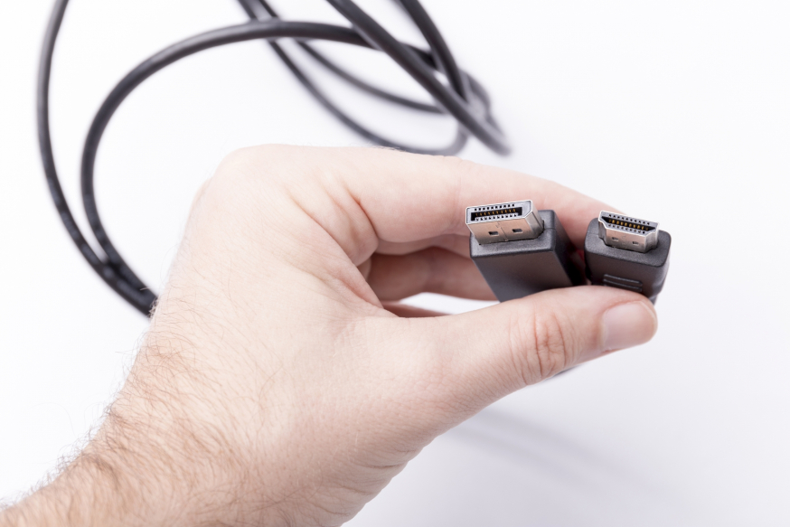 Afbeelding: een DisplayPort en HDMI kabel beiden vastgehouden door een persoon