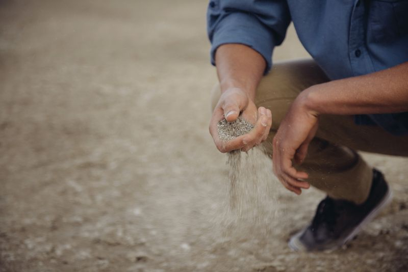 Man laat zand uit z'n hand glijden