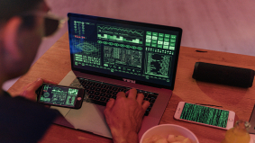 Laptop en smartphone met code en monitoring-schermen, illustratie van cyberaanval